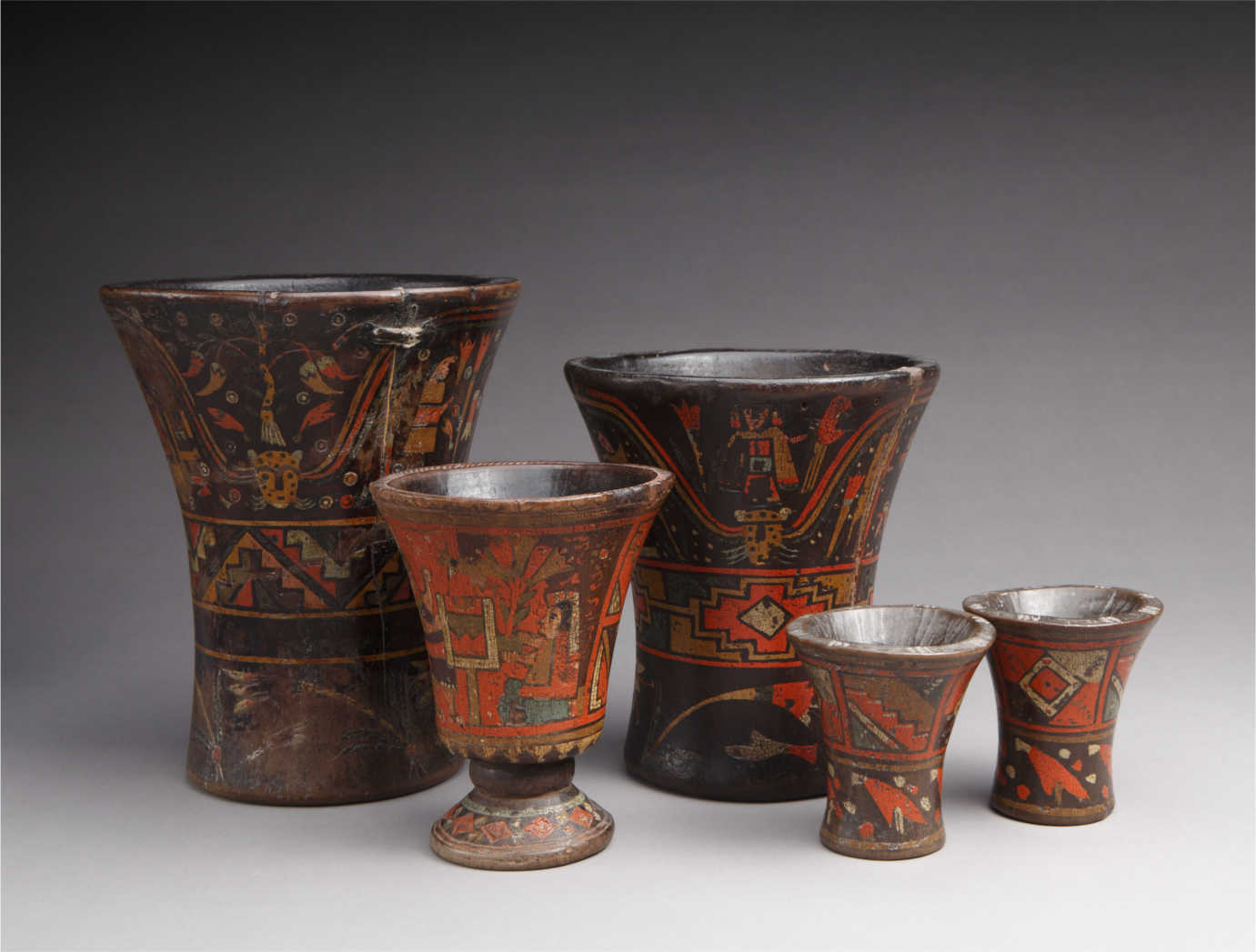 From *The Red That Colored the World*. Collection of wooden of Keros, Peru, 17th circa 18th century. Wood, paint, 8 3/8 x 6 7/8 in., 5 &frac12; x 4 &frac12; in., 3 3/8 x 3 &frac14; in. Private collection. Photograph by Addison Doty. Image courtesy of the Museum of International Folk Art.