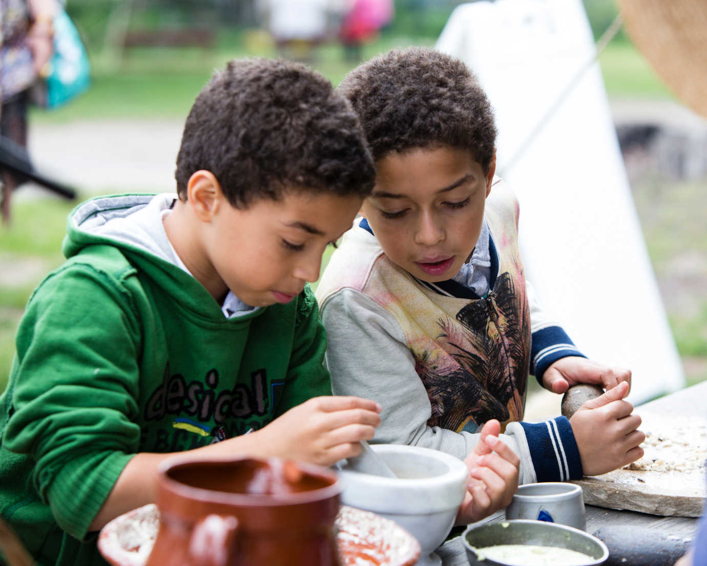 Two children examine a mortar and pestle&mdash;commonly used in eighteenth-century cooking and medicine. Image courtesy of Historic Hudson Valley.